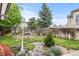 Backyard features a rock water feature, landscaping, mature trees, and decorative statues at 5146 S Argonne St, Centennial, CO 80015