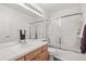 Bright bathroom features a vanity with a large mirror and a shower-tub combination with sliding glass doors at 5146 S Argonne St, Centennial, CO 80015