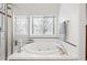 A bathtub in a bathroom with a glass-enclosed shower and tiled walls at 5146 S Argonne St, Centennial, CO 80015