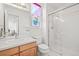 Bright bathroom featuring a glass-enclosed shower, white fixtures, and a vanity with ample counter space at 5146 S Argonne St, Centennial, CO 80015