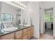 Bathroom with double sinks, a large mirror, tile floor, and an entrance to a walk-in closet at 5146 S Argonne St, Centennial, CO 80015