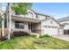Charming home featuring a covered porch, manicured lawn, and an attached three-car garage at 5146 S Argonne St, Centennial, CO 80015