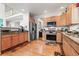 Well-equipped kitchen with stainless steel appliances, wood cabinets, and granite countertops at 5146 S Argonne St, Centennial, CO 80015