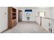 Bright loft area featuring plush carpeting, a window with blue valance, and built-in wood shelving at 5146 S Argonne St, Centennial, CO 80015