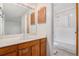 Bathroom featuring a single sink vanity, wood accents and a shower over tub at 2750 S Rifle St, Aurora, CO 80013