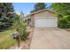Charming home featuring a two-car garage, stone accents and mature trees in a lush green lawn at 2750 S Rifle St, Aurora, CO 80013