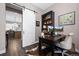 Inviting office space with a sliding barn door, built-in shelving, a work desk, and wood flooring at 2144 Bellcove Dr, Castle Pines, CO 80108