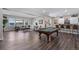 Spacious recreation room with a pool table, wet bar, comfortable seating, and hardwood floors at 2144 Bellcove Dr, Castle Pines, CO 80108
