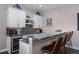 Stylish wet bar featuring sleek countertops, custom cabinets, a wine cooler, and bar seating at 2144 Bellcove Dr, Castle Pines, CO 80108