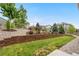 Well-maintained backyard with a retaining wall, lush lawn, and mature trees at 9781 Eagle River St, Littleton, CO 80125
