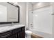 Full bathroom featuring modern dark cabinets, granite countertop, new white toilet, and tub with white subway tile at 9781 Eagle River St, Littleton, CO 80125