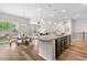Modern kitchen featuring an island, hardwood floors, and an adjacent dining area at 9781 Eagle River St, Littleton, CO 80125