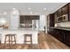 This kitchen features dark cabinets, granite countertops, tile backsplash, and stainless appliances with a convenient island at 9781 Eagle River St, Littleton, CO 80125