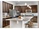 Stylish kitchen features dark cabinets, stainless steel appliances, granite countertops, island with barstool seating, and pendant lights at 9781 Eagle River St, Littleton, CO 80125