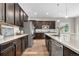 Modern kitchen with dark cabinetry, stainless steel appliances, granite countertops, and a center island with barstool seating at 9781 Eagle River St, Littleton, CO 80125