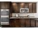 This kitchen features stainless steel appliances, granite countertops, stone backsplash, and dark brown cabinets at 9781 Eagle River St, Littleton, CO 80125