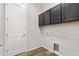 Functional laundry area with upper cabinets and modern flooring at 9781 Eagle River St, Littleton, CO 80125