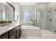 Bright main bathroom featuring dark wood cabinets, granite counters, a soaking tub, and a glass shower at 9781 Eagle River St, Littleton, CO 80125