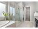 Bright main bathroom featuring a soaking tub with tile surround and a glass enclosed shower stall at 9781 Eagle River St, Littleton, CO 80125