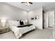 Cozy main bedroom featuring neutral walls, plush carpet, ceiling fan, and a dark barn door to the bathroom at 9781 Eagle River St, Littleton, CO 80125