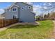 Green backyard with partial fence, exterior blue siding, and landscaping at 3475 Golden Spur Loop, Castle Rock, CO 80108