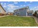 Spacious backyard featuring lush green grass, a patio area and a two-story house with blue siding at 3475 Golden Spur Loop, Castle Rock, CO 80108