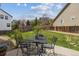 View of backyard patio with table and chairs, lush grass and wooden fence surrounding the perimeter at 3475 Golden Spur Loop, Castle Rock, CO 80108