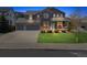 Charming two-story home with a three car garage and a welcoming front porch at twilight at 3475 Golden Spur Loop, Castle Rock, CO 80108