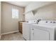 This laundry room features a washer and dryer, utility sink, cabinets, shelving and a window for natural light at 3475 Golden Spur Loop, Castle Rock, CO 80108