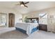 Bright main bedroom featuring neutral colors, a ceiling fan, and ensuite bath access at 3475 Golden Spur Loop, Castle Rock, CO 80108