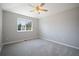 Neutral bedroom with a ceiling fan, large window, and neutral carpet at 17235 Opal Hill Dr, Parker, CO 80134
