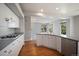 Open-concept kitchen with white cabinetry, stainless steel dishwasher, and view of living area at 17235 Opal Hill Dr, Parker, CO 80134