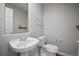 Clean and simple powder room featuring a pedestal sink, a toilet, and a mirror at 17235 Opal Hill Dr, Parker, CO 80134