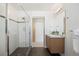 Bright bathroom featuring floating wood vanity, granite counter and glass shower at 3930 Yates St, Denver, CO 80212