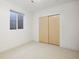 Bright bedroom with a large window, neutral walls, soft carpeting, and a spacious closet for organized storage at 3930 Yates St, Denver, CO 80212