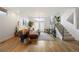 Bright and airy living room with hardwood floors, a brown sectional sofa, and a view of the staircase at 3930 Yates St, Denver, CO 80212