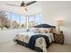 Serene main bedroom with bay window, plush bedding, stylish lamps, and a ceiling fan for added comfort at 3930 Yates St, Denver, CO 80212