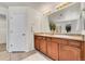 Bathroom featuring dual sink vanity, tile floors, and ample storage at 10622 Racine St, Commerce City, CO 80022