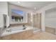 Bathroom with tiled tub and separate glass enclosed shower at 10622 Racine St, Commerce City, CO 80022