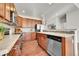 Modern kitchen with wood cabinets, stainless steel appliances, and tile backsplash at 10622 Racine St, Commerce City, CO 80022