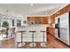 Open kitchen with a bar-style counter, stainless steel appliances, and hardwood floors at 10622 Racine St, Commerce City, CO 80022