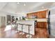 Open kitchen with a bar-style counter, stainless steel appliances, and hardwood floors at 10622 Racine St, Commerce City, CO 80022