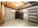 Unfinished basement with exposed ceiling, shelving, and natural light from two windows at 1302 S Cape Way, Lakewood, CO 80232