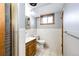 Bright bathroom features a wood-framed mirror, ceramic tile, and a wooden cabinet at 1302 S Cape Way, Lakewood, CO 80232