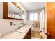 Bathroom featuring a vanity and shower with classic tile and fixtures at 1302 S Cape Way, Lakewood, CO 80232