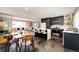 Open concept kitchen with island seating, dark cabinets and appliances, and adjacent to the living room at 1302 S Cape Way, Lakewood, CO 80232