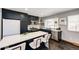 Contemporary kitchen featuring a large island with seating, stainless steel appliances, and dark cabinetry at 1302 S Cape Way, Lakewood, CO 80232