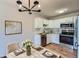 Bright kitchen features white cabinetry, stainless steel appliances, and marble countertops, complemented by a modern chandelier at 3184 S Heather Gardens Way # 302, Aurora, CO 80014
