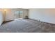 Bright living room with sliding glass doors to balcony and plush gray carpeting at 3184 S Heather Gardens Way # 302, Aurora, CO 80014