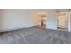 Spacious living room with gray carpet, leading to a modern kitchen with white cabinets at 3184 S Heather Gardens Way # 302, Aurora, CO 80014